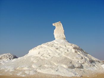 White rock formation in desert against clear blue sky