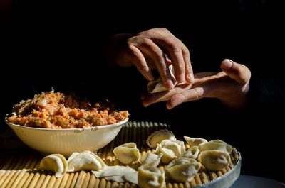 Midsection of person preparing food on table in darkroom