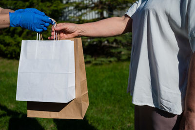 Midsection of man holding paper on field