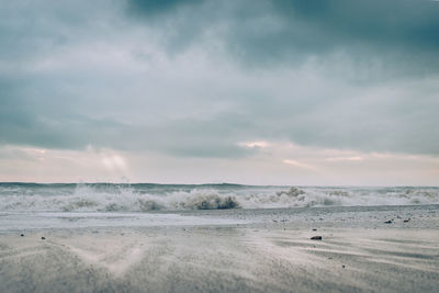 Scenic view of beach against dramatic sky