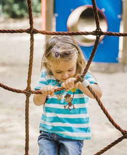 Girl standing on rope at playground