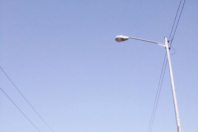 Low angle view of power lines against clear blue sky
