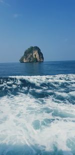 Scenic view of rocks in sea against blue sky