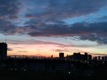 View of cityscape against cloudy sky during sunset