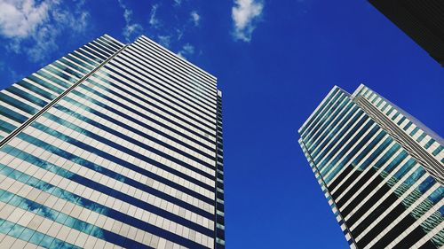 Low angle view of modern buildings against blue sky