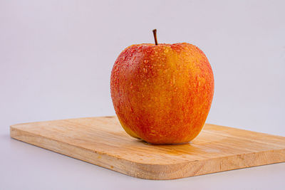 Close-up of apple on table against white background
