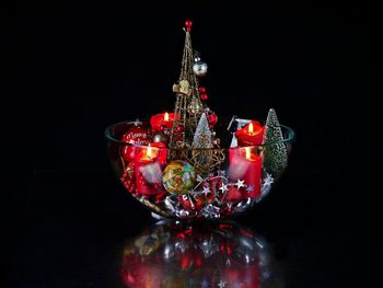 Illuminated christmas lights on table against black background