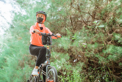 Young man riding bicycle on field