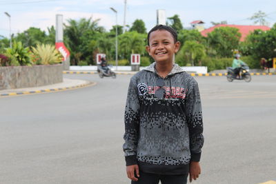 Portrait of young woman standing on road