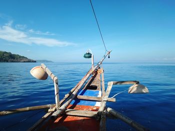 Fishing boat in sea against blue sky