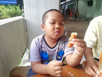 Boy holding food at table