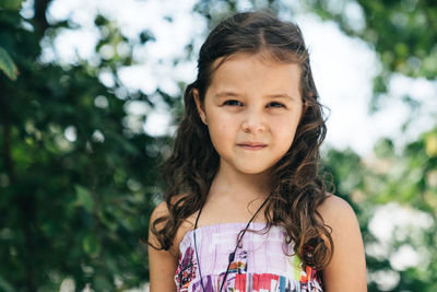 Portrait of girl against trees