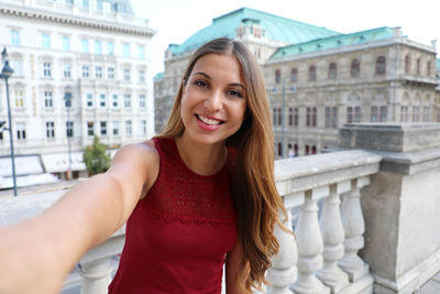 Portrait of smiling young woman in city