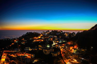 Illuminated cityscape against sky at night