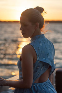 Woman looking at sea during sunset