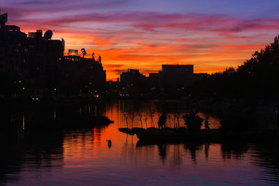 Silhouette of boats in river during sunset