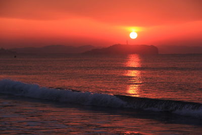 Scenic view of sea against orange sky