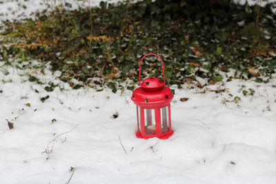 Close-up of lantern  on snow covered field