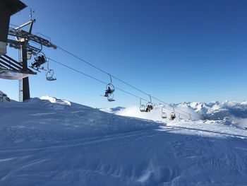 Overhead cable car over snowcapped mountains against sky