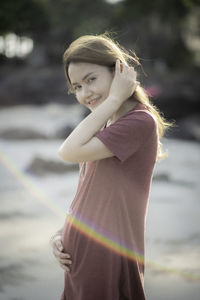 Portrait of young woman standing outdoors