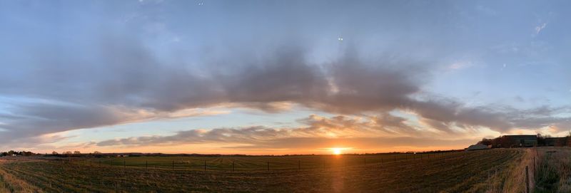 Panoramic view of field against sky during sunset
