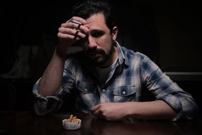 Portrait of young man sitting on table