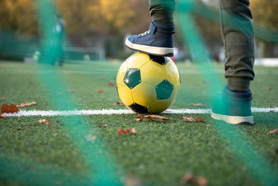 A little boy plays soccer with his father on the soccer field