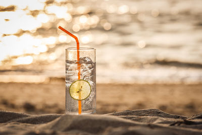 Close-up of glass of water on beach