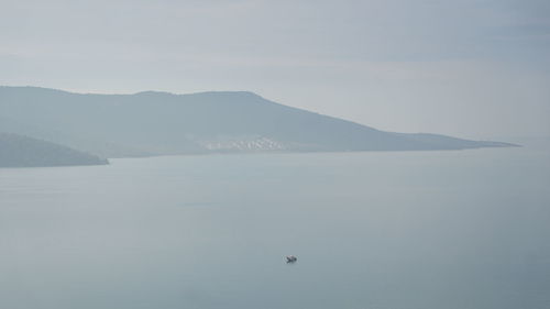 Scenic view of sea and mountains against sky