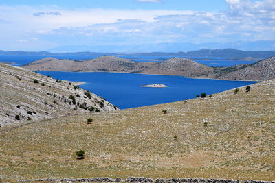 Scenic view of sea and mountains against sky