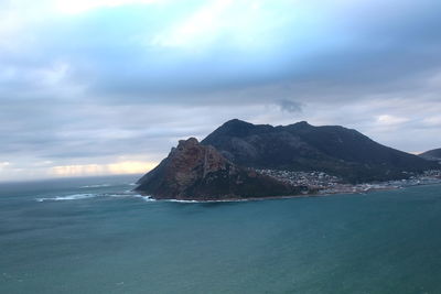 Scenic view of sea and mountains against sky