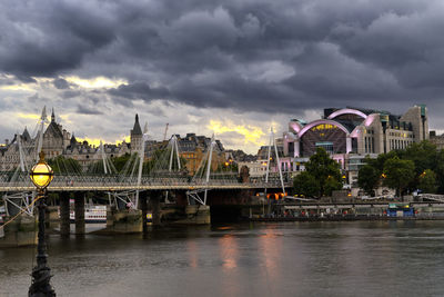 Bridge over river against cloudy sky