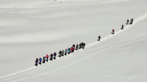 High angle view of people walking on snow