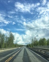 Road by trees against sky