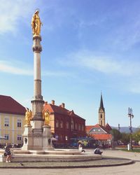 Statues against buildings in city