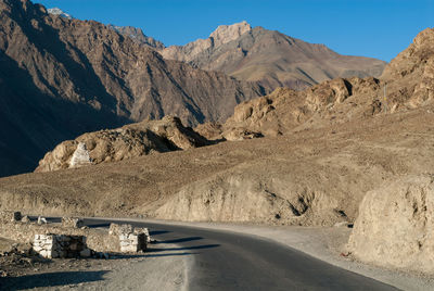 Road amidst mountains against clear sky