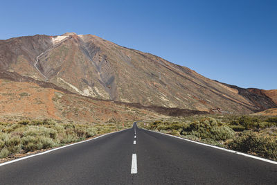 Road by mountain against clear sky