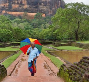 Full length of man walking on wet road during rainy season