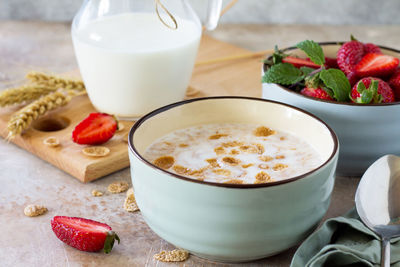 Healthy breakfast - whole grain flakes, milk and fresh strawberries. 