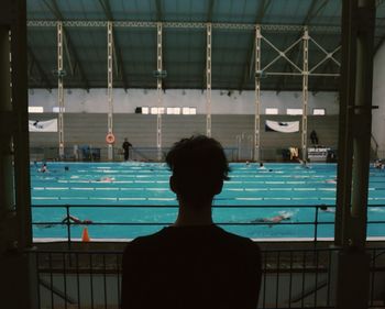 Rear view of young man against swimming pool