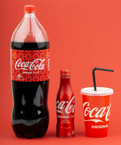 Close-up of drink served on table against red background