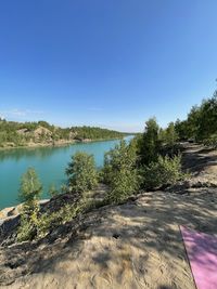 Scenic view of lake against clear blue sky