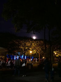 People on illuminated street at night