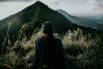 Man standing on field against mountains