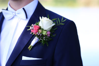 Low section of man holding flower bouquet