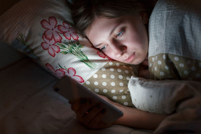 Sleepy woman awake late at night in bed surfing in web, can not fall asleep/ sleepy tired