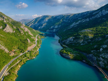 High angle view of river amidst mountains against sky