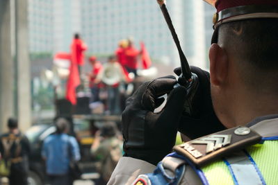Close-up of police man using walkie-talkie in city