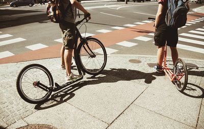 Low section of people riding bicycle on road