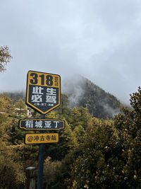 Low angle view of road sign against sky